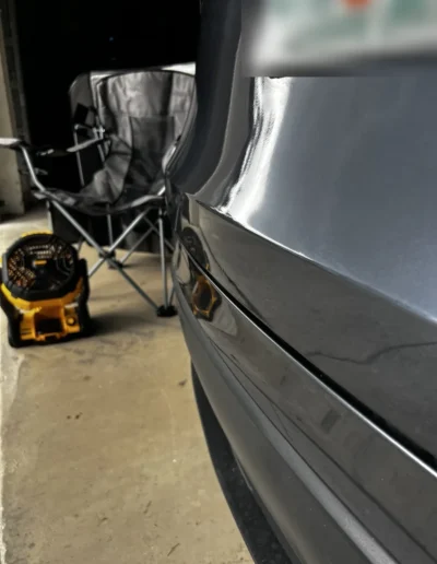 Paintless dent repair on a gray car's trunk lid